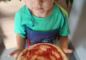 Dziecko z własnoręcznie zrobioną pizzą.