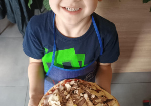 Dziecko z własnoręcznie zrobioną pizzą.