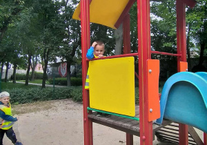 Dzieci radośnie bawią się na placu zabaw w parku.
