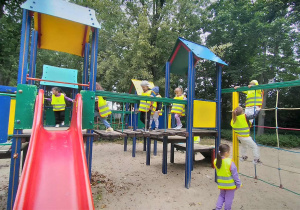 Dzieci radośnie bawią się na placu zabaw w parku.