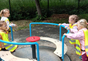 Dzieci radośnie bawią się na placu zabaw w parku.