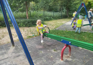 Dzieci radośnie bawią się na placu zabaw w parku.