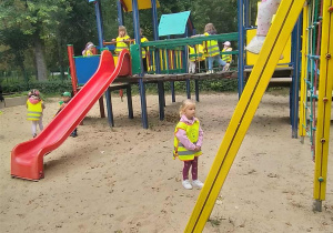 Dzieci radośnie bawią się na placu zabaw w parku.