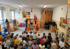 Dzieci oglądają teatrzyk pacynkowy.