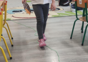 Dziecko idzie po linii noga za nogą.