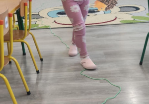 Dziecko idzie po linii noga za nogą.