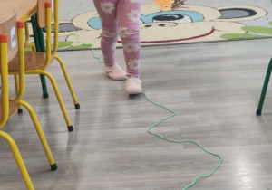 Dziecko idzie po linii noga za nogą.
