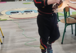 Dziecko idzie po linii noga za nogą.