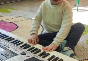 Dziecko gra na keyboardzie.