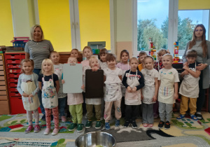 Dzieci w fartuszkach przed robieniem sałatki jarzynowej.