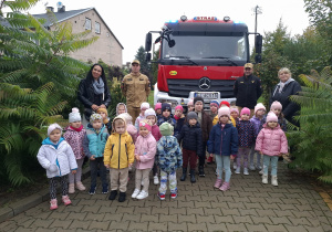 Zdjęcie grupowe ze strażakami przed autem strażackim.