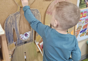 Dziecko wkłada do sylwety produkt spożywczy.