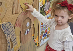 Dziecko wkłada do sylwety produkt spożywczy.