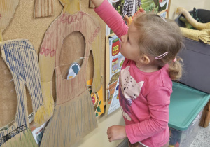 Dziecko wkłada do sylwety produkt spożywczy.