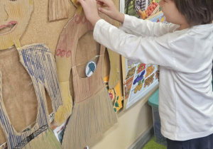 Dziecko wkłada do sylwety produkt spożywczy.