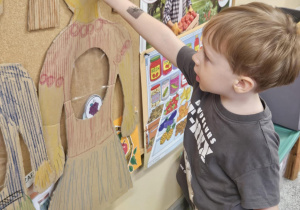 Dziecko wkłada do sylwety produkt spożywczy.