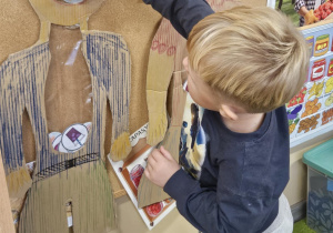 Dziecko wkłada do sylwety produkt spożywczy.