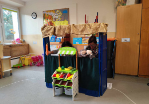 Dzieci oglądają teatrzyk pacynkowy.