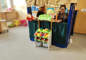 Dzieci oglądają teatrzyk pacynkowy.