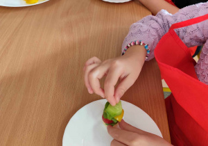 Dzieci przygotowują koreczki z warzyw.