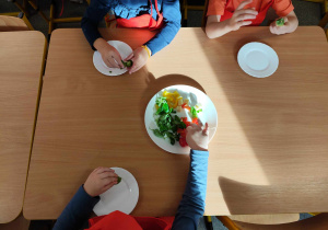 Dzieci przygotowują koreczki z warzyw.