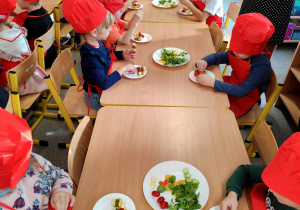 Dzieci przygotowują koreczki z warzyw.