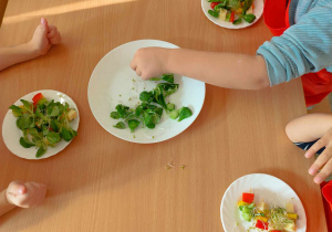 Dzieci przygotowują koreczki z warzyw.