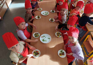 Dzieci przygotowują koreczki z warzyw.