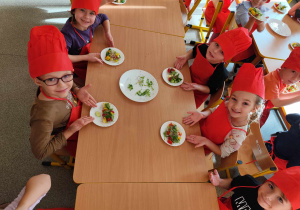 Dzieci przygotowują koreczki z warzyw.
