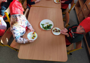 Dzieci przygotowują koreczki z warzyw.