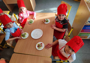 Dzieci przygotowują koreczki z warzyw.