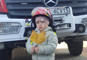 Dziecko w kasku strażackim.