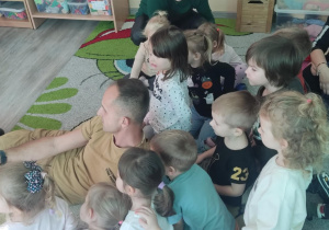 Strażak pokazuje dzieciom kamerę termowizyjną.