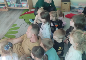 Strażak pokazuje dzieciom kamerę termowizyjną.