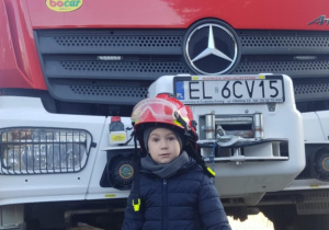 Dziecko w kasku strażackim.