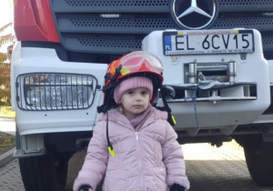 Dziecko w kasku strażackim.