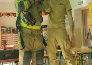 Strażacy pokazują strój.