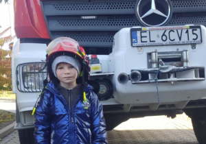 Dziecko w kasku strażackim.