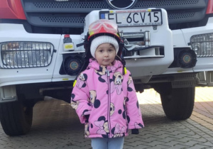 Dziecko w kasku strażackim.