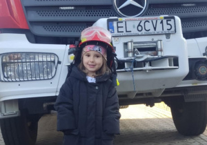 Dziecko w kasku strażackim.