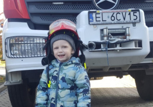 Dziecko w kasku strażackim.