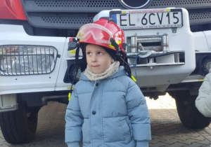 Dziecko w kasku strażackim.