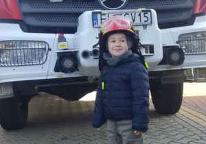 Dziecko w kasku strażackim.