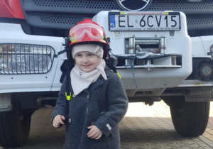 Dziecko w kasku strażackim.