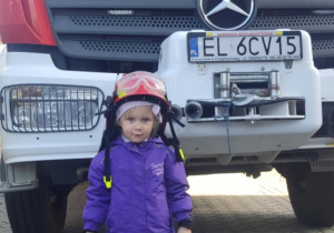 Dziecko w kasku strażackim.