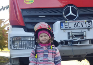 Dziecko w kasku strażackim.