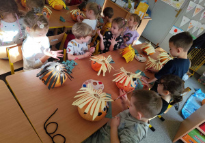 Dzieci tworzą postacie z dyni.