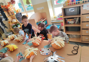 Dzieci tworzą postacie z dyni.