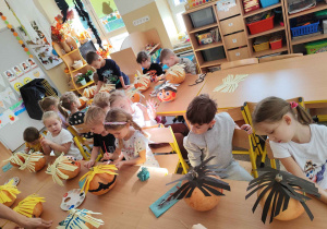 Dzieci tworzą postacie z dyni.