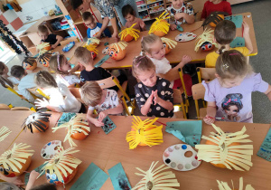 Dzieci tworzą postacie z dyni.